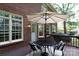 Back porch with outdoor table and seating, umbrella, exterior door, and large windows at 1587 Summit View Dr, Rock Hill, SC 29732