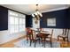 Formal dining room featuring dark blue walls, wood floors, and an elegant chandelier at 1587 Summit View Dr, Rock Hill, SC 29732