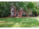 Brick home with manicured lawn, mature trees, and front door with black trim at 1587 Summit View Dr, Rock Hill, SC 29732