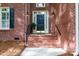 Inviting brick porch entrance with elegant black door and charming lantern-style sconces at 1587 Summit View Dr, Rock Hill, SC 29732