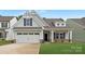 Inviting home featuring a two-car garage, charming porch, and well-maintained lawn at 170 Aspire Cir # 31, Wingate, NC 28174