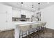 A modern kitchen featuring sleek white cabinets, a stylish island with seating, and pendant lighting at 170 Aspire Cir # 31, Wingate, NC 28174