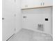 Modern laundry room with updated cabinets, white walls, and tile flooring at 170 Aspire Cir # 31, Wingate, NC 28174
