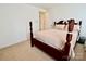 Bedroom with carpet, neutral walls and a dark wooden four-poster bed at 2008 Bantry Ln, Charlotte, NC 28262