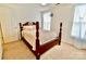 Well-lit bedroom featuring carpet and a wooden four-poster bed by the window at 2008 Bantry Ln, Charlotte, NC 28262