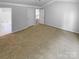 A spacious bedroom boasts neutral walls, carpet, and two doorways leading to other parts of the house at 2010 Kansas City Dr, Monroe, NC 28110