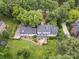 Aerial view of house with mature trees, lush lawn, and a wooden deck at 2032 Greenbrook Pkwy, Matthews, NC 28104