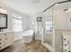 Bright bathroom features a soaking tub, glass shower, and double sink vanity with wooden-look floor at 2032 Greenbrook Pkwy, Matthews, NC 28104