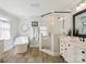 Bright bathroom with a soaking tub, separate glass shower, and double sinks with wooden-look floors at 2032 Greenbrook Pkwy, Matthews, NC 28104