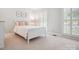 Cozy bedroom with white wood bed frame, natural light, and three framed pictures adorning the wall at 2032 Greenbrook Pkwy, Matthews, NC 28104