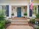 Inviting entrance with a blue door, brick steps, and lush landscaping with flowers at 2032 Greenbrook Pkwy, Matthews, NC 28104