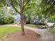 An exterior view of a beautiful home with mature landscaping and a circular driveway at 2032 Greenbrook Pkwy, Matthews, NC 28104