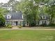 The front exterior boasts a lush lawn, brick steps, and a charming blue front door at 2032 Greenbrook Pkwy, Matthews, NC 28104