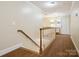 Hallway showing wood railing, a small table, and view of a room through the doorway at 2032 Greenbrook Pkwy, Matthews, NC 28104