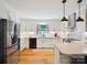 Bright kitchen features white cabinets, stainless steel appliances, granite counters, and hardwood floors at 2032 Greenbrook Pkwy, Matthews, NC 28104