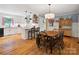 Charming kitchen with white cabinets, modern island, and adjacent dining area featuring a wooden table and chairs at 2032 Greenbrook Pkwy, Matthews, NC 28104