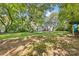 Large backyard featuring patio, house, playhouse, mature trees and ample space for outdoor activities at 2034 Lanier Ave, Charlotte, NC 28205
