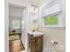 Well-lit bathroom with a modern vanity and large window offering natural light and a view to the outside at 2034 Lanier Ave, Charlotte, NC 28205