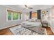 Relaxing bedroom with natural light, wood floors, ceiling fan and a decorative patterned rug at 2034 Lanier Ave, Charlotte, NC 28205