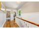 Hallway featuring hardwood floors, wainscoting, storage closets, and natural light from a window at 2034 Lanier Ave, Charlotte, NC 28205