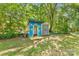 Backyard playhouse featuring bright colors and playful design nestled in a shady backyard at 2034 Lanier Ave, Charlotte, NC 28205