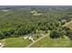 Picturesque aerial view of a home and pool set amidst a mix of open fields and dense forest at 247 Helton Rd, Cherryville, NC 28021