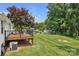 Expansive backyard featuring a wood deck, inground pool, storage sheds, and lush greenery at 247 Helton Rd, Cherryville, NC 28021