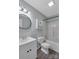 Modern bathroom with a shower-tub combo, white vanity, round mirror and wood-look floors at 247 Helton Rd, Cherryville, NC 28021