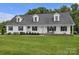 This house boasts a welcoming front porch with rocking chairs, dormer windows, and a lush lawn at 247 Helton Rd, Cherryville, NC 28021