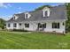 Charming house boasts a covered porch with rocking chairs and black shutters with hanging plants at 247 Helton Rd, Cherryville, NC 28021