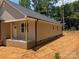 Tan home featuring a welcoming covered porch with classic brick trim and a view of the surrounding greenery at 2560 S Jake Alexander S Blvd, Salisbury, NC 28146