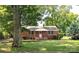 Charming single story brick home featuring a well manicured lawn and mature trees at 309 Fannie Cir, Charlotte, NC 28205
