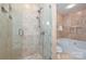 Elegant bathroom features a glass-enclosed shower and soaking tub with travertine tile surround at 333 W 7Th St, Charlotte, NC 28202