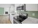 Modern kitchen featuring stainless steel appliances, white countertops, and a view of the fireplace at 3433 Spinner Ct, Sherrills Ford, NC 28673