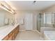 Large bathroom featuring a double sink vanity, glass enclosed shower, and soaking tub at 3533 Weddington Ridge Ln, Matthews, NC 28105