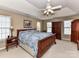 Warm and inviting primary bedroom with a tray ceiling, large bed, and wooden furniture at 3533 Weddington Ridge Ln, Matthews, NC 28105