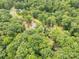 Stunning aerial view of a wooded property with a house, pond, and lush greenery at 3547 Willowood Pond Dr, Rock Hill, SC 29730