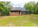 Inviting home featuring a covered front porch with brick foundation, metal roof, and verdant lawn at 3547 Willowood Pond Dr, Rock Hill, SC 29730