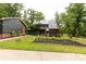 A quaint home with a metal roof and an adjacent vegetable garden featuring raised beds, surrounded by greenery at 3547 Willowood Pond Dr, Rock Hill, SC 29730