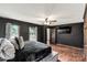 Dark bedroom featuring hardwood floors, TV, ceiling fan, windows, and exit to an outdoor area at 3547 Willowood Pond Dr, Rock Hill, SC 29730