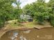 Scenic view of home next to the pond with a dock surrounded by lush trees on a large lot at 3547 Willowood Pond Dr, Rock Hill, SC 29730