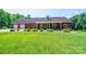 Well-maintained brick home with lush lawn, complemented by manicured landscaping and a welcoming entrance at 4010 Carlton Dr, Claremont, NC 28610