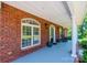 Covered front porch featuring brick columns, rocking chairs, and decorative touches with an inviting atmosphere at 4010 Carlton Dr, Claremont, NC 28610