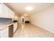 Open-concept living room with tile flooring and view of kitchen with white cabinets at 4010 Carlton Dr, Claremont, NC 28610