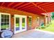 Covered outdoor patio area featuring brick walls, neutral concrete, and bright double french doors at 4010 Carlton Dr, Claremont, NC 28610