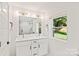 Modern bathroom with double sink vanity, black hardware, and a shower with glass door at 4101 Tipperary Pl, Charlotte, NC 28215