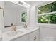 Bright bathroom featuring double sinks with gold faucets and a large window at 4101 Tipperary Pl, Charlotte, NC 28215