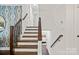 Bright staircase featuring white walls and wooden steps, leading to the upper level at 4101 Tipperary Pl, Charlotte, NC 28215