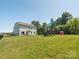 Large backyard featuring a play set, grassy lawn and the exterior of the home at 4535 Falls Lake Sw Dr, Concord, NC 28025