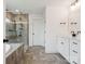 Modern bathroom with a glass-enclosed shower, tub, double vanity, and tile flooring at 4535 Falls Lake Sw Dr, Concord, NC 28025